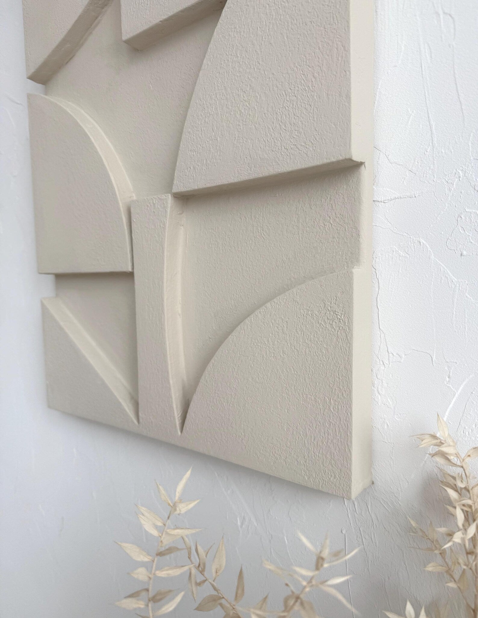 wabi sabi textured plaster wall art above sofa in neutral interior