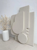 Decorative concrete shelf with abstract design on a light gray surface and white wall background