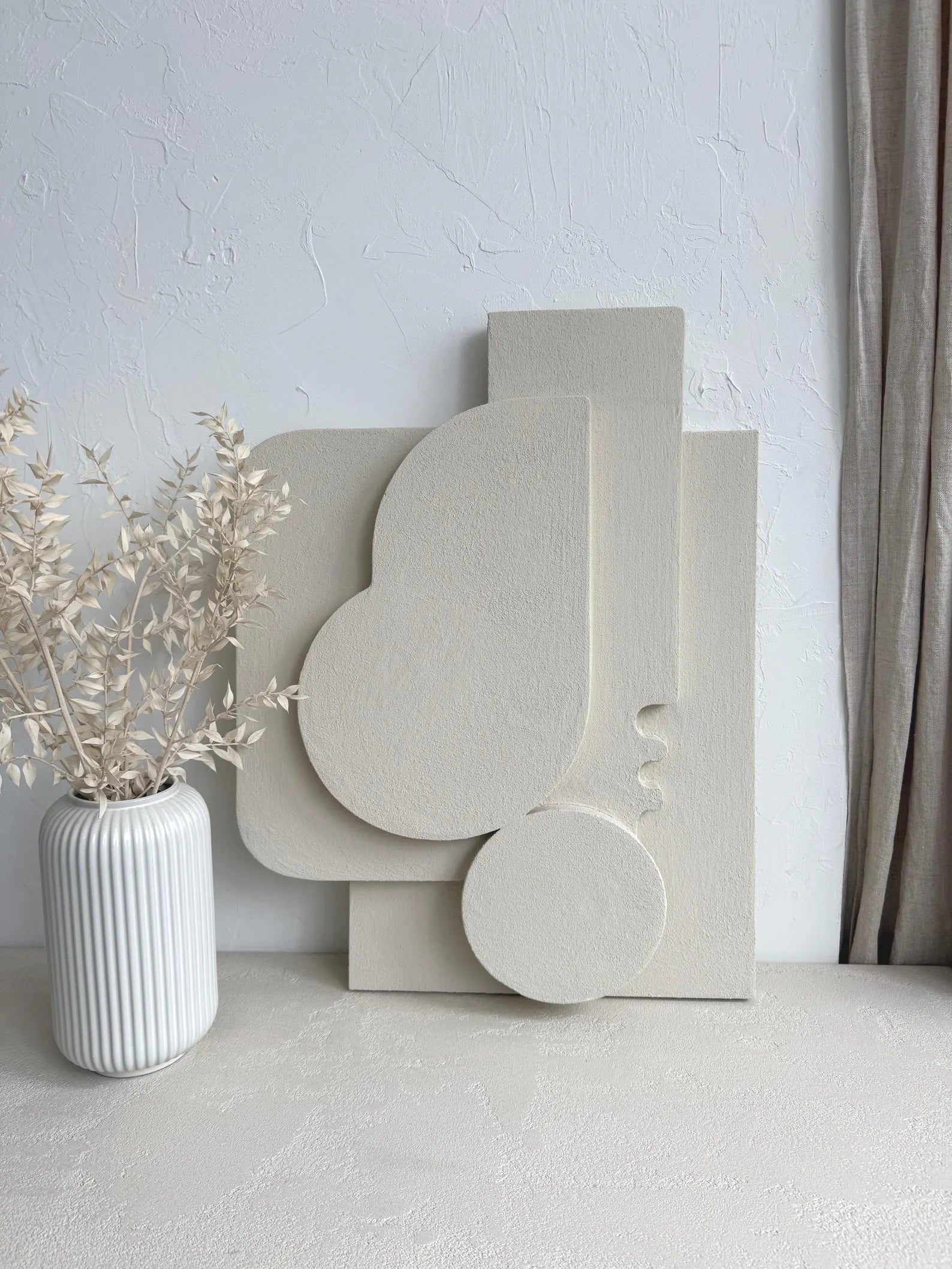 Decorative white sculptures on a light surface with a neutral background